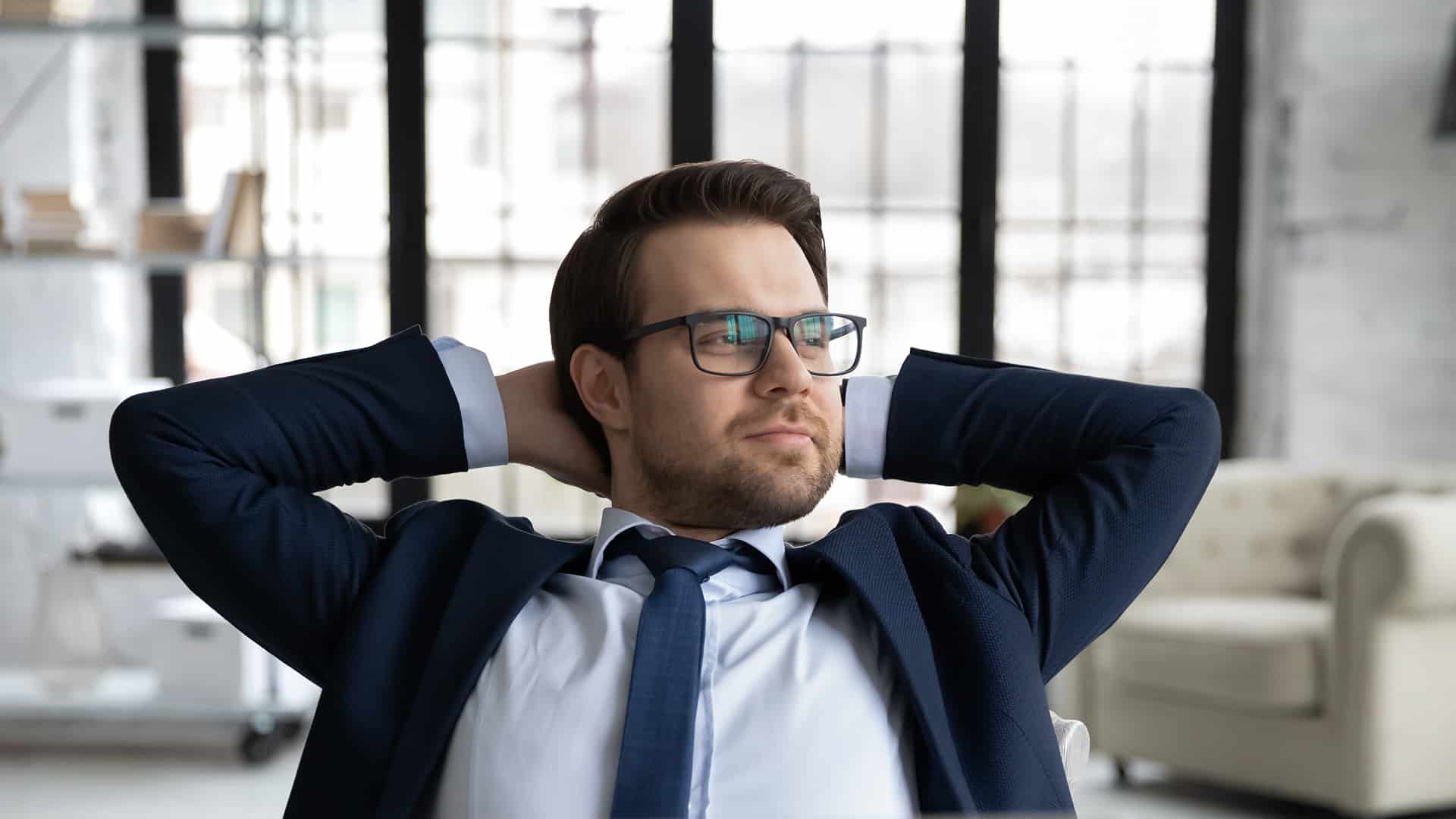 Close up dreamy businessman wearing glasses leaning back, dreaming